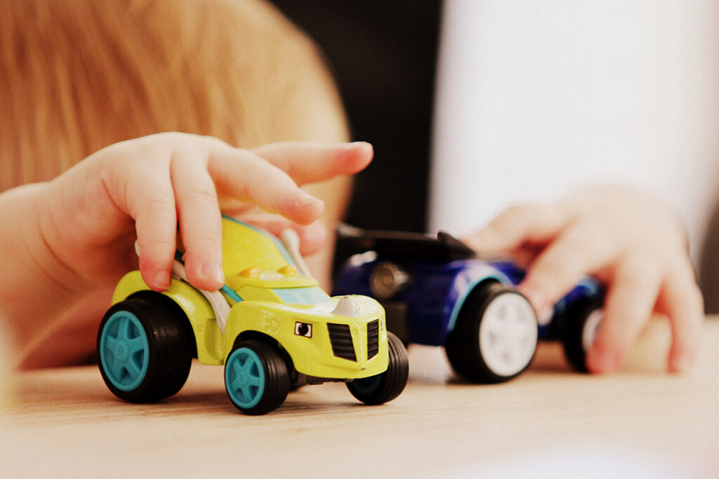 Child playing with toy tractor